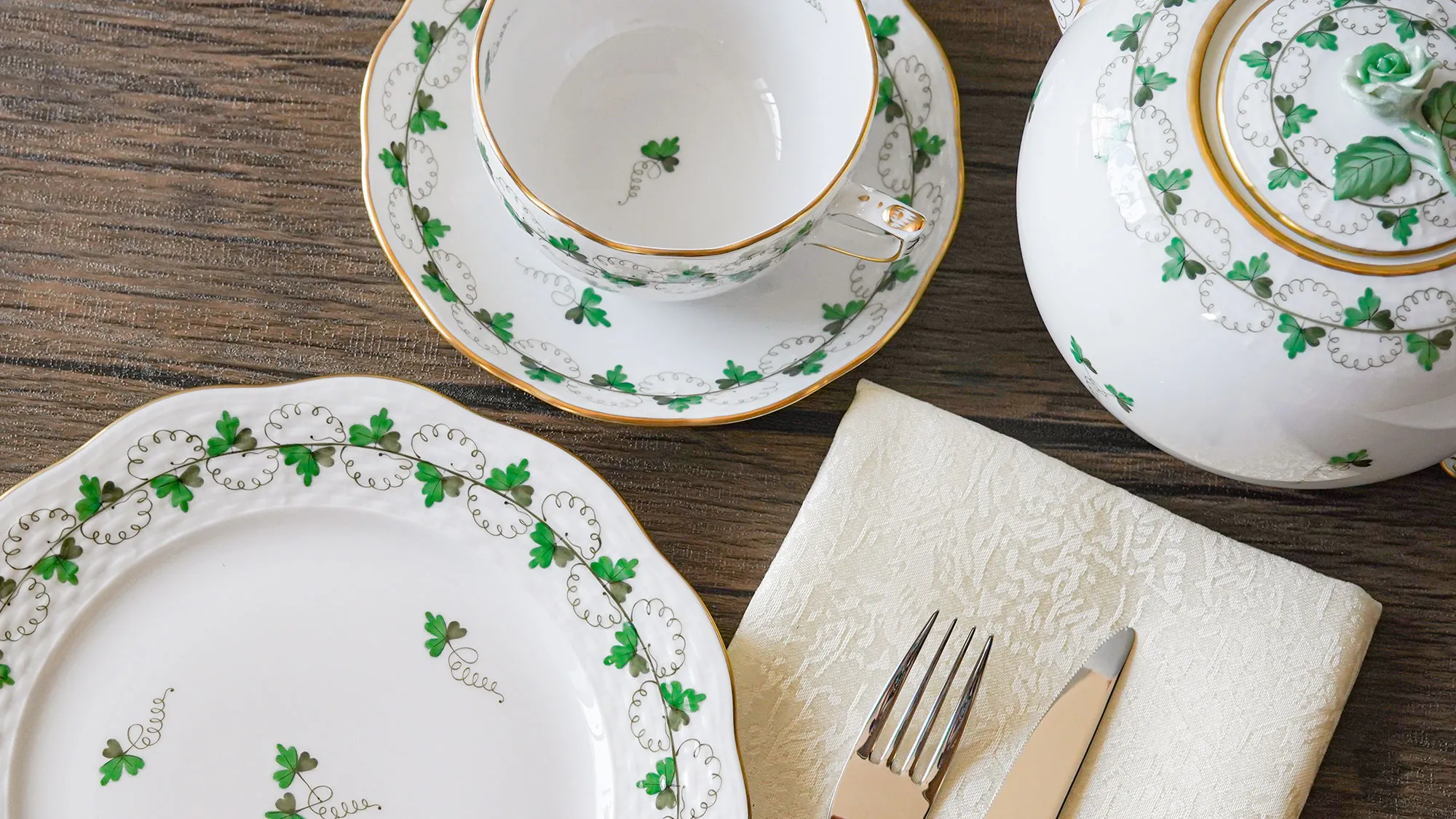 ヘレンド パセリグリーンのプレート・ティーカップ＆ソーサー・ティーポットをナプキンとカトラリーと共に並べたテーブル