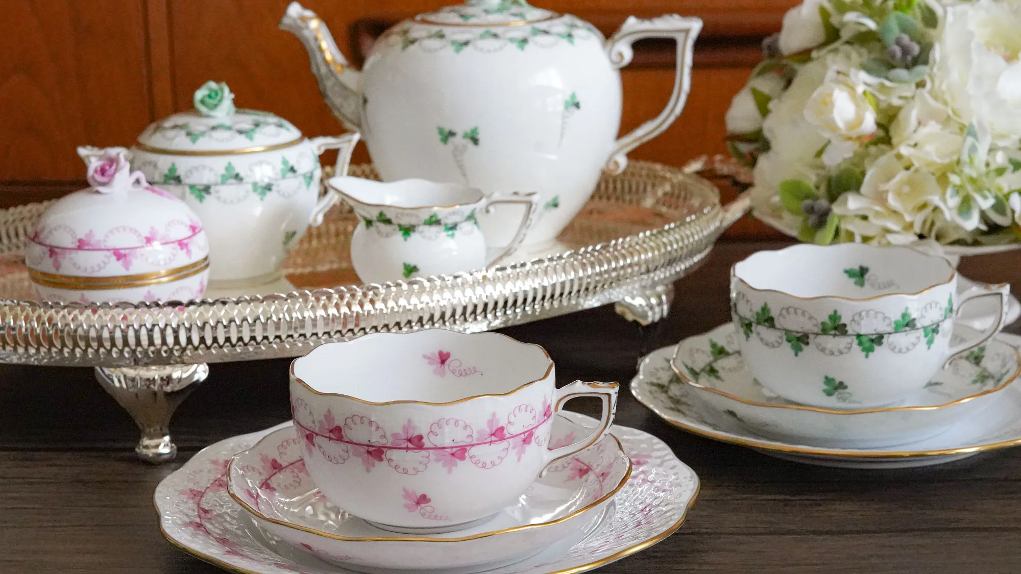 ヘレンド パセリのティーセット（グリーンとピンク）をシルバートレイに配し、花を添えたテーブル